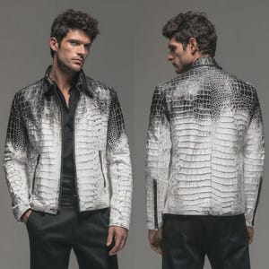 May include: A white and black leather jacket with a crocodile skin pattern. The jacket has a zipper closure and a collar. The jacket is worn by a person in the image. The jacket is a stylish piece of outerwear.