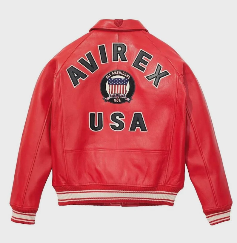 May include: A red leather jacket with the word "AVIREX" arched across the shoulders in black and white lettering. Below the word "AVIREX" is a circular patch with the words "ALL AMERICANS" and a US flag design. The word "USA" is printed below the patch.