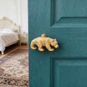 May include: A white ceramic mug with a black handle and the text "But First, Coffee" in a black, handwritten-style font. The mug is on a white surface.