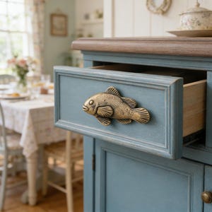 May include: A trio of cream-glazed ceramic mugs, each adorned with a hand-painted floral pattern in blue, green, and yellow. The mugs have a speckled finish and a classic, rounded design with a handle for easy grip.