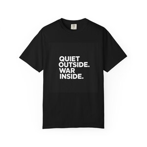 May include: Black t-shirt with the white text "QUIET OUTSIDE. WAR INSIDE." The shirt has short sleeves and a crew neck. The text is centered on the front of the shirt.
