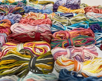 May include: A collection of colorful cotton cords, each wound into a ball, with a variety of colors and patterns.
