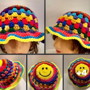 May include: A colorful crocheted sun hat with a yellow smiley face. The hat is made with a variety of colors, including red, orange, yellow, green, blue, and purple. The brim of the hat is wide and floppy.