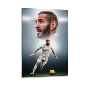 以下が含まれることがあります： サッカー選手の肖像画が描かれたキャンバスプリント。選手がアクションを起こしている2枚目の画像も含まれています。選手はFly Emiratesのロゴが入った白いジャージを着て、黄色と黒のサッカーボールを蹴っています。