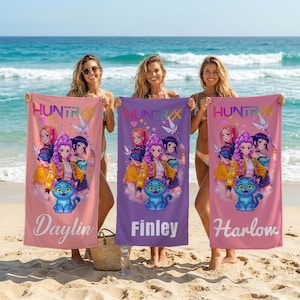 May include: Three beach towels with a cartoon graphic of anime-style characters and a blue cat. The towels are pink, purple, and light pink, each with a different name: Daylin, Finley, and Harlow. The word "HUNTRX" is at the top of each towel.
