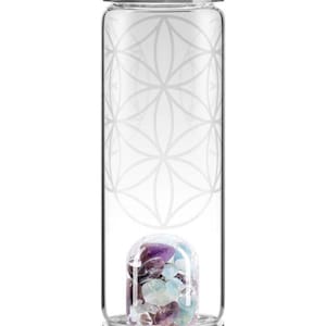 May include: A clear glass water bottle with a silver-toned metal cap and base. The exterior features a white etched geometric flower of life pattern. Inside the base, a small glass chamber contains a collection of polished purple and blue stones.