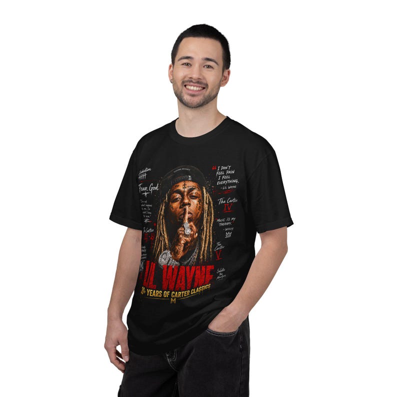 Puede incluir: Una camiseta negra de manga corta con un estampado gr&aacute;fico de Lil Wayne con rastas, gorra y joyas. El dise&ntilde;o incluye texto en rojo que dice LIL WAYNE, 20+ YEARS OF CARTER CLASSICS, y varias citas y t&iacute;tulos de canciones en color blanco.