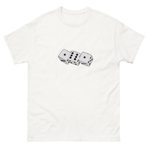 May include: White t-shirt with a graphic of three dice, each showing a different number of dots. The dice are arranged in a row, with one, four, and two dots visible. The shirt is made of a soft material.