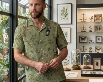 May include: A short-sleeved button-down shirt in olive green featuring a repeating pattern of various insects, moths, and botanical leaves. The shirt has a classic collar and white buttons. The text KolBasShop is visible in the bottom right corner.
