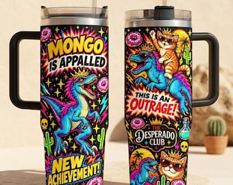 May include: Two stainless steel tumblers with handles and straws, featuring a vibrant black background with colorful illustrations of a blue dinosaur and an orange cat wearing crowns, plus text reading Mongo Is Appalled, New Achievement, and The Desperado Club.
