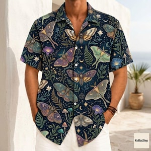 May include: A short-sleeve button-down shirt in a dark navy blue color featuring an all-over print of various moths, green ferns, small white flowers, and golden stars. The shirt has a classic collar and a front button closure with white buttons.