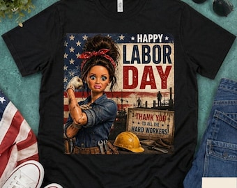 May include: A black t-shirt featuring a graphic of a person with a red bandana, wearing a denim shirt and work gloves. The background shows an American flag, a yellow hard hat, and text that reads Happy Labor Day Thank You To All The Hard Workers.