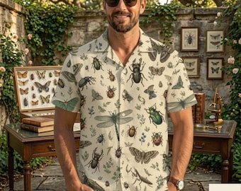 May include: A short-sleeved button-down shirt in a light cream color featuring an all-over print of various insects, including beetles, dragonflies, butterflies, and moths, along with small botanical sprigs and leaves.