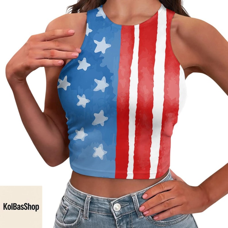 K&ouml;nnte beinhalten: Ein &auml;rmelloses Crop-Top mit patriotischem Design. Die linke Seite zeigt einen blauen Hintergrund mit wei&szlig;en Sternen, w&auml;hrend die rechte Seite rote und wei&szlig;e Streifen aufweist. Der Text "KolBasShop" ist sichtbar.