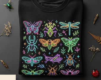 May include: A black crewneck sweatshirt featuring a vibrant neon-style graphic print of various insects including butterflies, beetles, dragonflies, and moths in bright shades of pink, blue, green, orange, and yellow, accented with small stars.