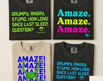 May include: Four t-shirts arranged in a grid. Two black shirts feature the green text: GRUMPY. ANGRY. STUPID. HOW LONG SINCE LAST SLEEP. QUESTION? One black shirt has the text Amaze. in cyan, yellow, and magenta. One beige shirt has blue text.