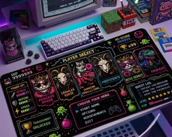 May include: A rectangular black desk mat featuring a vibrant pixel art interface with a player selection menu, character portraits including a cat and a goat, and game stats. The design includes neon-colored text and icons on a dark background.