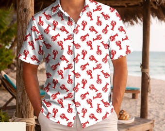 May include: A short-sleeved button-down shirt featuring an all-over repeating pattern of bright red lobsters on a crisp white background. The shirt has a classic collar, a front button placket, and a straight hemline, providing a clean look.