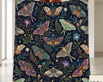 May include: A dark blue throw blanket featuring a repeating pattern of various moths, ferns, mushrooms, and celestial symbols like stars and crescent moons. The moths are depicted in shades of purple, gold, green, and brown with intricate wing details.