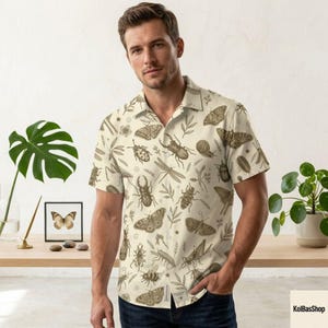 May include: A short-sleeve button-down shirt in a light cream color featuring an all-over print of various brown insects, beetles, and moths interspersed with small botanical leaf illustrations and a classic collar design.