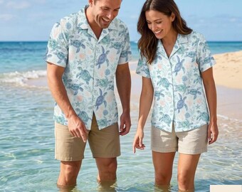 May include: A short-sleeved button-down shirt featuring a light blue and white pattern of sea turtles, starfish, and coral. The shirt has a classic collar, a front button placket, and a straight hem, showcasing a repeating marine life print.