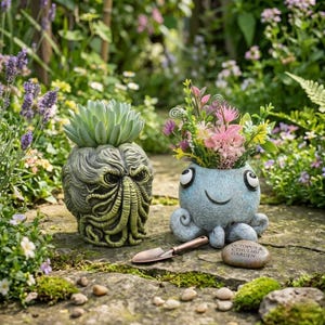 May include: Two whimsical garden planters. One is a green, tentacled monster head with a succulent. The other is a blue octopus with a smiling face, filled with colorful flowers. A small trowel and a stone with text are in front.