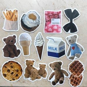 May include: A collection of stickers featuring various food items and teddy bears. Includes stickers of french fries, a pastry, ice cream cones, a milk carton, a cookie, waffles, and several teddy bear designs.