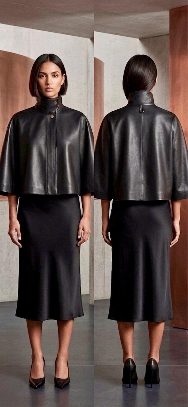 May include: A black leather cape jacket with a high collar and button fastening, worn with a black midi skirt. The model is wearing black heels. The outfit is shown from the front and back.