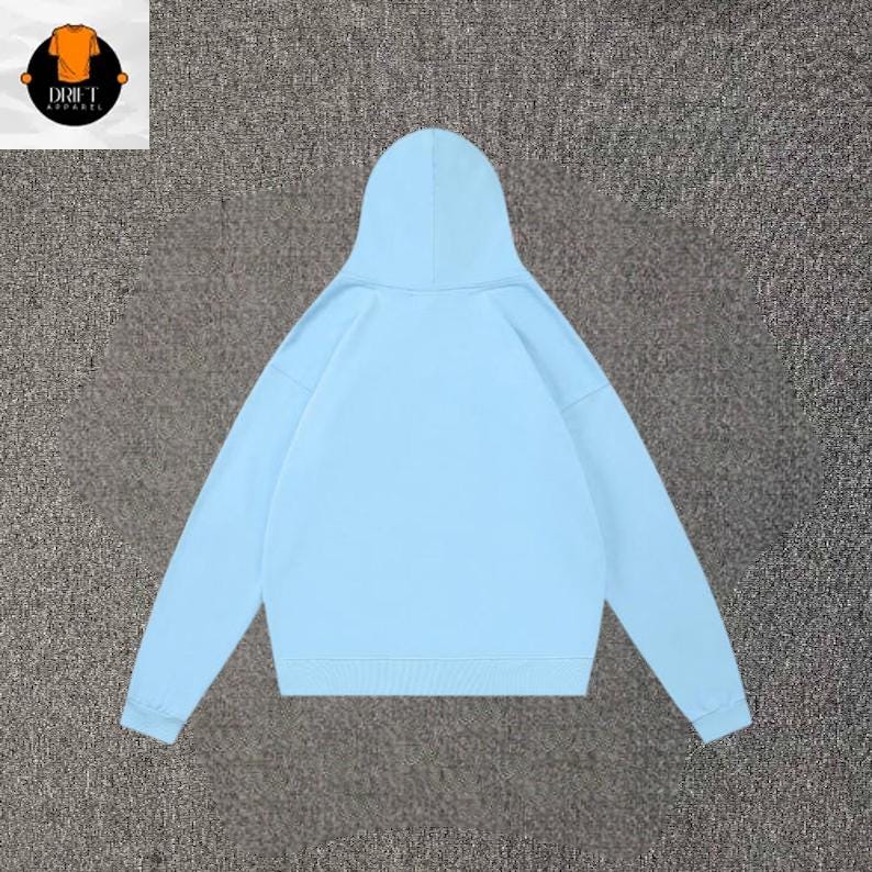 May include: A light blue hooded sweatshirt featuring long sleeves, a hood, and ribbed cuffs at the wrists and hem. The garment is displayed from the back, showing a plain, solid-colored fabric design with no visible logos, patterns, or text on the back.
