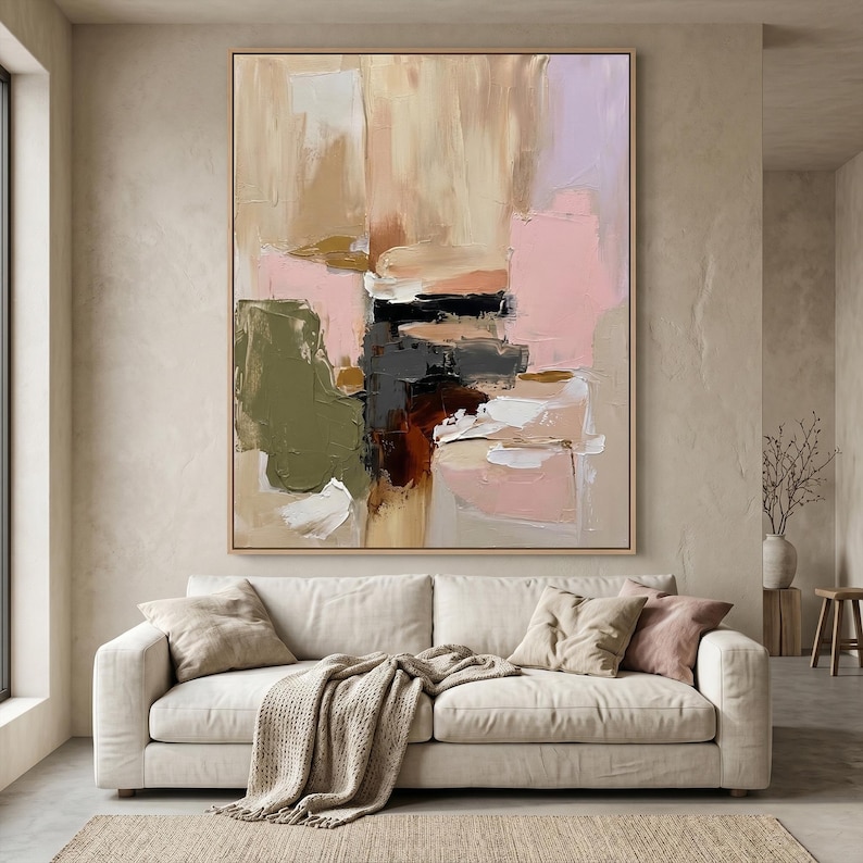 Puede incluir: Una gran pintura abstracta rectangular con pinceladas gruesas y texturizadas en tonos beige, rosa suave, verde oliva, marr&oacute;n oscuro y negro, enmarcada en madera clara y expuesta en una pared neutra sobre un sof&aacute; de color beige.