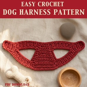 Op de afbeelding: Een rood gehaakt hondentuigpatroon met de tekst "EASY CROCHET DOG HARNESS PATTERN" bovenaan. Een gehaakt bot en een houten kom staan ook in de afbeelding. De woorden "PDF DOWNLOAD" staan onderaan.