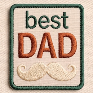 May include: A rectangular embroidered patch with a cream-colored background and a dark green border. The text best is stitched in dark green, while the word DAD is in large, bold orange letters. Below the text is a cream-colored mustache design.