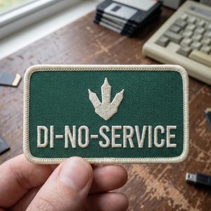 May include: A rectangular green patch with a white border and the text "DI-NO-SERVICE" in white. Above the text is a white dinosaur footprint. The patch is held in a hand.