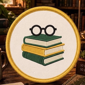 May include: A circular embroidered patch featuring a stack of three books with green and yellow covers, topped with a pair of black round glasses. The patch has a white background and a thick, golden-yellow stitched border around the edge.
