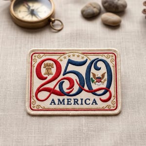 May include: A rectangular embroidered patch on a cream background featuring the number 250 in red and blue thread. The number 2 includes a gold Liberty Bell, the 0 features a bald eagle emblem, and the word AMERICA is stitched in blue below.