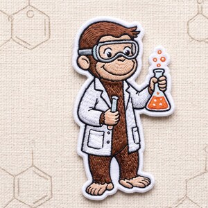 May include: An embroidered patch featuring a brown monkey dressed as a scientist in a white lab coat and safety goggles. The monkey holds a small test tube in one hand and a glass Erlenmeyer flask filled with orange liquid and bubbles in the other.