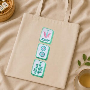 Pastel mahjong tile embroidery on a natural fabric bag for small accessories.
