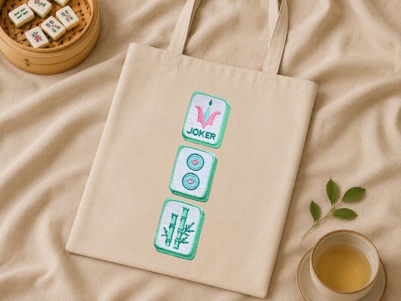 Pastel mahjong tile embroidery on a natural fabric bag for small accessories.