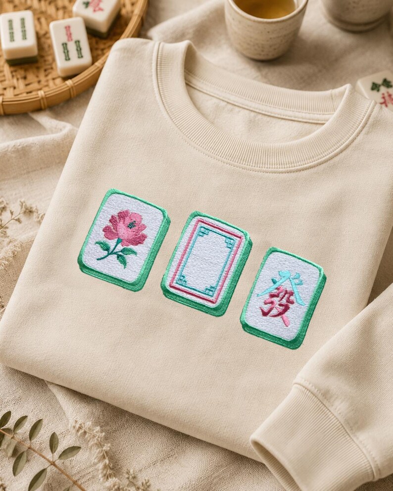 Mahjong embroidery design stitched on a beige sweatshirt.