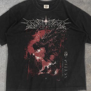May include: Black t-shirt with a red and black dragon graphic, the text reads "Alduin The World Eater" and "The Elder Scrolls V Skyrim". The design is centered on the front of the shirt.