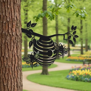 Könnte beinhalten: Ein Wandkunstobjekt aus schwarzem Metall, das einen Bienenstock zeigt, der an einem Ast mit Blättern und zwei Bienen hängt. Das Design ist eine flache Silhouette mit Aussparungen für den Eingang und die Flügel, montiert an einem Baumstamm.