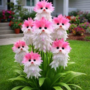 May include: A whimsical garden arrangement featuring seven decorative flower sculptures. Each sculpture has a pink and white feathered design, with black eyes and a small beak, resembling a bird. The sculptures are set against a backdrop of green grass and foliage.