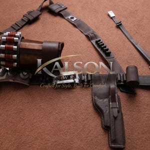 May include: A brown leather utility belt with a holster, ammunition storage, and various pouches. The belt features a shoulder strap and is designed for carrying equipment. The text "KALSON" is visible.