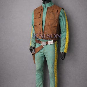 May include: A costume featuring a teal jumpsuit with yellow side stripes, a brown vest with pockets, and a matching belt with a holster. The costume is displayed on a mannequin. The text "KALSON" is visible on the chest.