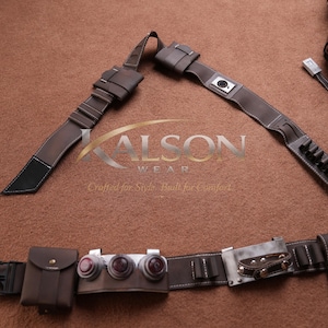 May include: Brown leather belt and accessories set. The set includes a belt with multiple pouches, a holster, and straps. The leather is stitched with white thread. The accessories are likely for cosplay or costume use.
