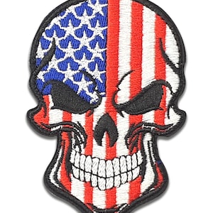 May include: Embroidered patch featuring a skull design with the American flag. The left side of the skull displays blue stars on a white background, while the right side has red and white stripes. The patch has a black border and a detailed, stitched appearance.