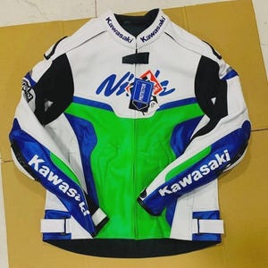 Könnte beinhalten: Eine weiße, grüne und blaue Kawasaki Motorradjacke. Die Jacke hat schwarze Akzente an Schultern und Ärmeln, mit dem Kawasaki-Logo. Ein "Protector"-Etikett ist angebracht.