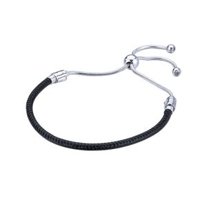 Op de afbeelding: Een zilverkleurige verstelbare armband met een zwarte, getextureerde band. De armband heeft een schuifkraal voor maatverstelling en kleine, heldere kristallen accenten. Eenvoudig en elegant ontwerp.