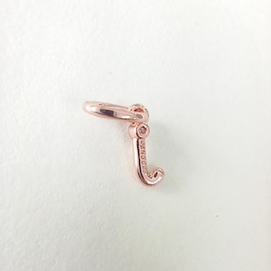 Puede incluir: Charm de oro rosa con forma de la letra "J". El charm tiene un pequeño lazo en la parte superior para sujetarlo a una pulsera o collar. La palabra "PANDORA" está grabada en el lateral de la letra.