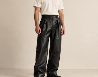 May include: A plain off-white short-sleeved crew neck t-shirt paired with black high-waisted leather trousers. The trousers feature a wide-leg silhouette, front pleats, a button and zipper fly closure, and are worn with black leather boots.